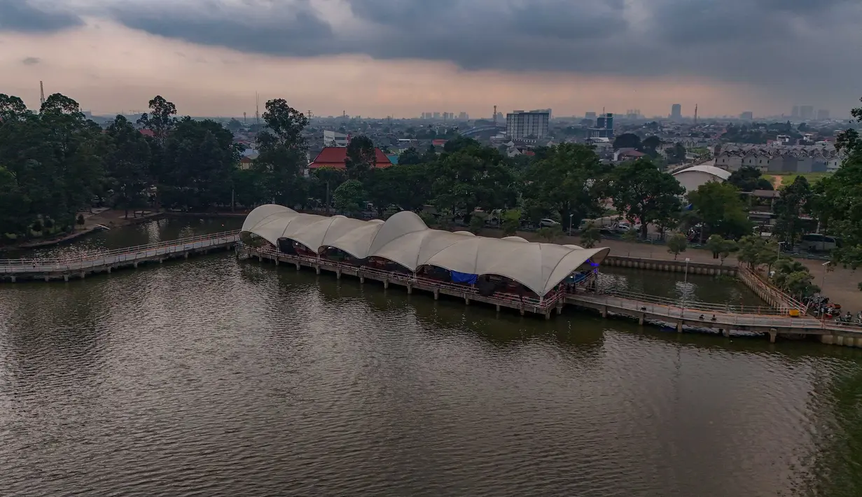 Pada sore hari, Situ Cipondoh ramai dikunjungi warga yang ingin menikmati pemandangan matahari terbenam. Tampak foto udara memperlihatkan area Situ Cipondoh di Kota Tangerang, Banten, yang tetap berfungsi sebagai kawasan konservasi air sekaligus destinasi rekreasi warga, Rabu (14/4/2026). (merdeka.com/Arie Basuki)
