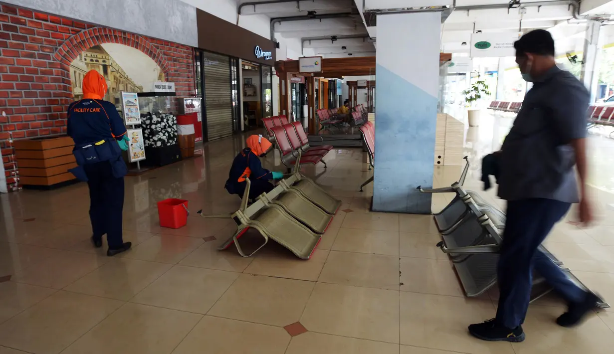 Petugas kebersihan melakukan aktivitas di Bandara Halim Perdanakusuma, Jakarta, Rabu (26/1/2022). Aktivitas keberangkatan dan kedatangan penumpang serta pertokoan dihentikan sementara dan dialihkan ke Bandara Soekarno-Hatta. (merdeka.com/Imam Buhori)