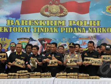 Ditnarkoba Mabes Polri berhasil mengamankan  2,1 ton ganja kering asal Aceh. Tampak, Kabareskrim Komjen Pol Budi Waseso (tengah - depan) menunjukkan barang bukti ganja di Lapangan Bhayangkara, Jakarta, Senin (11/5/2015). (Liputan6.com/JohanTallo)