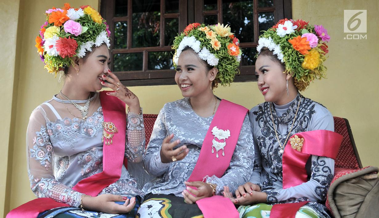 Sejumlah gadis bersenda gurau menunggu upacara adat Ngarot dimulai di Desa Lelea, Indramayu, Jawa Barat, Rabu (19/12). Ngarot digelar pada hari Rabu minggu ketiga di bulan Desember. (Merdeka.com/Iqbal Nugroho)