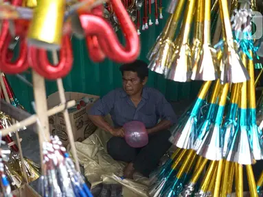 Pedagang terompet menunggu calon pembeli di kawasan Glodok, Jakarta, Jumat (27/12/2019). Menjelang perayaan Tahun Baru 2020, penjual terompet musiman mulai marak di sejumah kawasan dengan harga jual berkisar Rp5ribu hingga Rp15ribu tergantung model. (Liputan6.com/Immanuel Antonius)