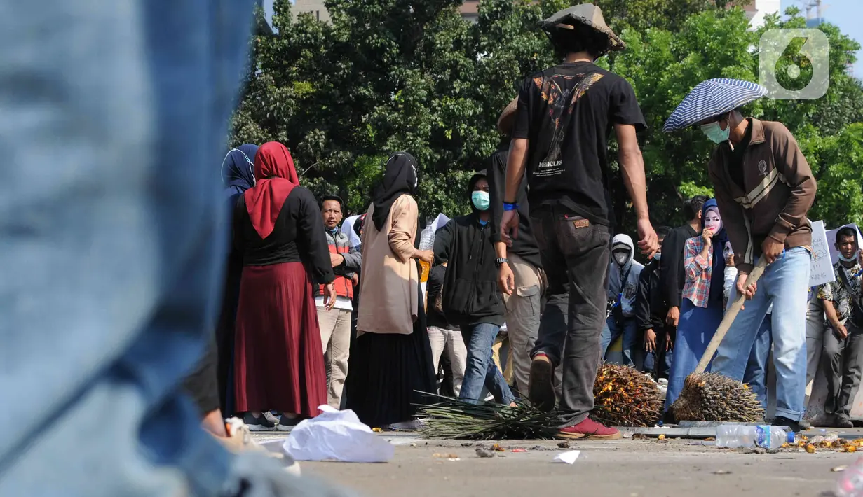 Sejumlah massa yang tergabung dalam Barisan Masyarakat Anti Korupsi, Kolusi dan Nepotisme (BASMI KKN) melakukan aksi teatrikal di kawasan Patung Kuda, Jakarta, Jumat (27/5/2022). Dalam aksi tersebut mereka menuntut pemerintah untuk mengatasi lonjakan harga dan kelangkaan minyak goreng di Indonesia. (Liputan6.com/Herman Zakharia)