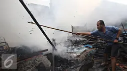 Warga membersihkan puing sisa kebakaran di kawasan Palmerah, Jakarta, Kamis (4/8). Api yang diduga berasal dari arus pendek itu membakar 8 rumah. (Liputan6.com/Immanuel Antonius)