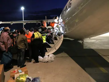 Ratusan calon penumpang berebut masuk ke pesawat Wings Air tujuan Makasar di Bandara Mutiara Palu, Selasa (2/10). Kemenhub membuka lalu lintas udara di pasca gempa pada hari Senin (1/10). (Liputan6.com/Fery Pradolo)