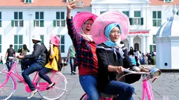 Pengunjung berswafoto sambil menaiki sepeda Onthel di Kawasan Kota Tua, Jakarta, Kamis (21/9). Kawasan Kota Tua menjadi salah satu tujuan warga Jakarta dan sekitarnya untuk mengisi libur Tahun Baru Islam. (Liputan6.com/Helmi Afandi)