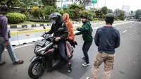 Seorang perempuan diselamatkan pendemo saat pengunjuk rasa terlibat bentrok dengan polisi di kawasan Patung Kuda, Jakarta, Selasa (13/10/2020). Perempuan tersebut terjebak saat unjuk rasa menolak Omnibus Law Undang-Undang Cipta Kerja ricuh. (Liputan6.com/Faizal Fanani)
