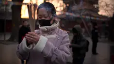 Seorang wanita memegang dupa berdoa di Kuil Lama di Beijing (5/2). Orang-orang China merayakan hari pertama Tahun Baru Imlek pada hari Selasa, Tahun Babi di zodiak Tiongkok dengan berdoa di kuil. (AP Photo/Mark Schiefelbein)