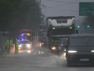 Kendaraan melintasi jalan yang sebagian tergenang air akibat hujan deras di Paju, Korea Selatan, Rabu, 17 Juli 2024. (AP Photo/Lee Jin-man)