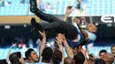 Manajer Manchester City Pep Guardiola dilemparkan ke udara oleh para pemainnya usai melawan Huddesfiel dalam pertandingan Liga Inggris di Etihad Stadium (6/5). (Martin Rickett/PAvia AP)
