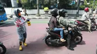 Petugas Srikandi Damkar Bandung sedang menyemprotkan cairan disinfektan kepada para pengendara kendaraan bermotor di Jalan Asia Afrika, Kota Bandung, Kamis (26/3/2020). (Humas Pemkot Bandung)