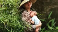 Chrissy saat belajar gendong bayi. (instagram.com/Chrissy Teigen)
