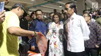 Presiden Joko Widodo berbelanja usai meresmikan Pasar Ikan Modern Muara Baru di Jakarta, Rabu (13/3). PIM Muara Baru yang menelan anggaran Rp150,68 miliar mengusung konsep pasar ikan yang higienis dan modern. (Liputan6.com/Angga Yuniar)