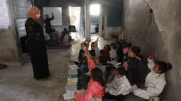 Di dalam tenda-tenda darurat, kamp pengungsi Jabalia, Jalur Gaza Utara, Sekolah Mada tetap beroperasi sebagai fasilitas pendidikan darurat di tengah konflik Israel dan Hamas yang masih berlangsung di Gaza. Tampak dalam foto, anak-anak pengungsi Palestina mengikuti belajar mengajar di dalam tenda di Sekolah Mada, kamp pengungsi Jabalia, Jalur Gaza Utara pada 13 April 2026. (Omar AL-QATTAA/AFP)