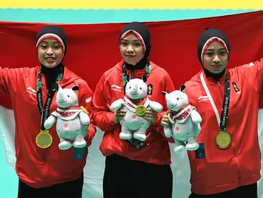 Tim pencak silat seni beregu putri Indonesia, Pramudita Yuristya (kiri), Lutfi Nurhasanah (tengah) dan Gina Tri Lestari (kanan) berpose usai meraih medali emas Asian Games 2018, Jakarta, Rabu (29/8). (ANTARA FOTO/INASGOC/Melvinas Priananda/nak/18)