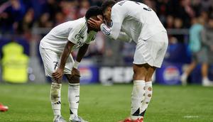 Jude Bellingham memberikan semangat kepada Vinicius Junior yang gagal mencetak gol via penalti saat Atletico menghadapi Real Madrid pada leg 2 babak perempat final Liga Champions 2024/2025 di Estadio Wanda Metropolitano, Kamis (13/3/2024) dini hari WIB. (Oscar DEL POZO CA&Ntilde;AS / AFP&nbsp;)