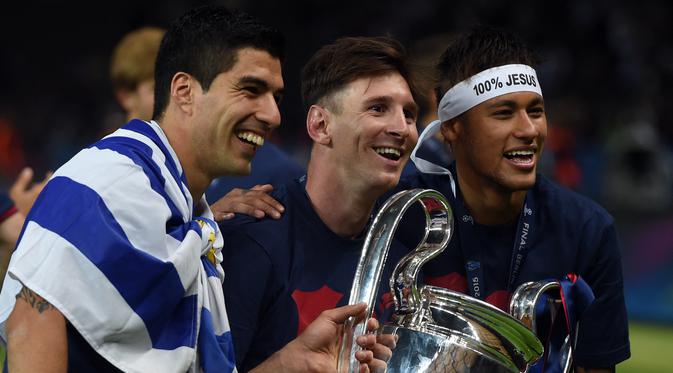 Lionel Messi (tengah) membawa trofi Liga Champions bersama Luis Suarez dan Neymar setelah menang melawan Juventus pada Final di Stadion Olimpiade di Berlin pada Juni 6, 2015. Messi sudah berstatus tanpa klub sejak tanggal 1 Juli 2021 mengingat kontraknya bersama Barcelona usai. (AFP/Patrik Stollarz)