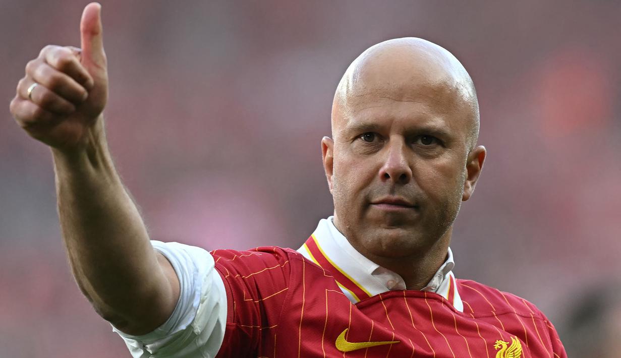 Pelatih Liverpool, Arne Slot mengacungkan jempolnya saat melakukan selebrasi setelah timnya dipastikan menyabet gelar juara Liga Inggris 2024/2025 setelah mengalahkan Tottenham Hotspur di Anfield, Liverpool, Inggris, Minggu (27/04/2025). (AFP/Paul Ellis)