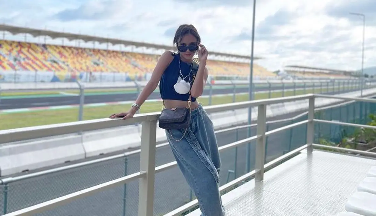 Angie Ang juga turut hadir di MotoGP Mandalika 2022. Presenter ini tampil bergaya casual memadukan crop top tanpa lengan, baggy jeans, dan sneakers. (Instagram/nonangie).
