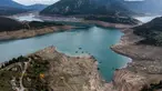 Foto ini menunjukkan sisa-sisa rumah yang muncul kembali ketika permukaan danau buatan Mornos menurun akibat kekeringan, di desa Kallio, sekitar 240 km barat laut Athena, Yunani pada 3 November 2025. Sebuah desa yang sudah tenggelam muncul kembali di Danau Mornos, Yunani pada 3 November 2025. (Angelos TZORTZINIS/AFP)