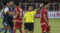 Wasit Aprisman Aranda menegur bek Persija Jakarta, Rezaldi Hehanussa, saat melawan Arema FC pada laga Liga 1 di SUGBK, Jakarta, Sabtu (31/3/2018). Persija menang 3-1 atas Arema FC. (Bola.com/Vitalis Yogi Trisna)
