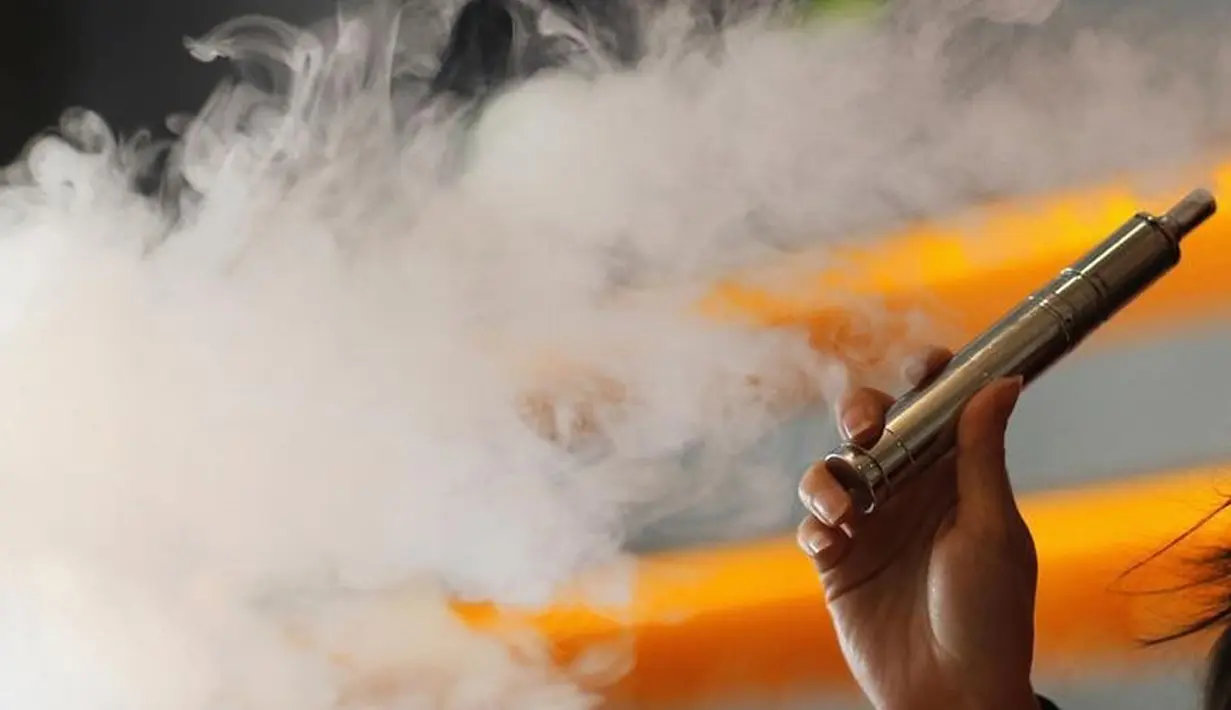 Seseorang menghisap rokok elektrik atau vape di sebuah toko rokok elektrik, The Vapor Spot vapor, Los Angeles, California, 14 Maret 2014. Peraturan juga melarang penjualan rokok elektrik kepada orang dibawah 18 tahun. (REUTERS/Mario Anzuoni)