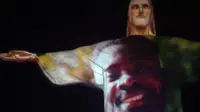 Patung Christ the Redeemer terlihat menyala untuk memberikan penghormatan kepada korban virus corona di Rio de Janeiro, Brasil, Rabu (1/7/2020). Covid-19 telah menewaskan sedikitnya 512.383 orang sejak pandemi itu muncul di China Desember 2019 lalu. (MAURO PIMENTEL / AFP)