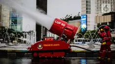 Petugas pemadam kebakaran menyemprotkan cairan disinfektan menggunakan robot LUF 60 di kawasan Bundaran HI, Jakarta, Minggu (22/3/2020). Pemprov DKI Jakarta melakukan penyemprotan fasilitas umum untuk mencegah penyebaran virus corona COVID-19. (Liputan6.com/Faizal Fanani)