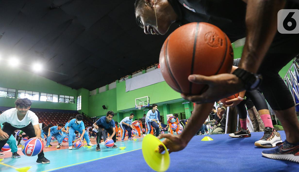 Siswa siswi Madrasah berlatih teknik dasar bola basket di GOR Bulungan Jakarta, Selasa (31/05/2022). Jr. NBA Indonesia mengajarkan dasar-dasar basket dan nilai-nilai inti program seperti Sportsmanship (Sportivitas), Teamwork (Kerja tim), a positive Attitude (Sikap positif), and Respect (Rasa hormat) (S.T.A.R.). (Liputan6.com/Fery Pradolo)