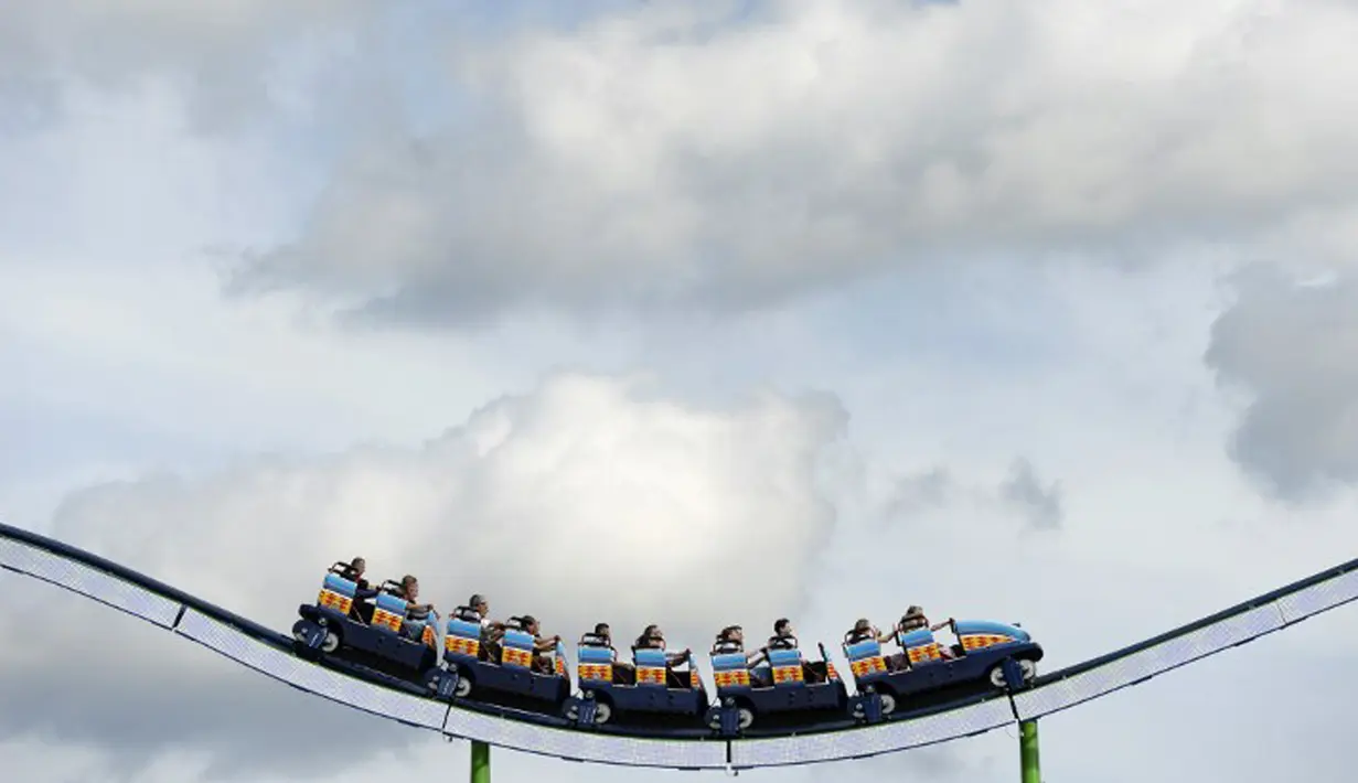 Pengunjung menaiki Roller Coaster di saat Festival Bir Oktoberfest di Munich, Jerman, (19/9/2015). Oktoberfest di Jerman adalah festival bir terbesar di dunia yang akan berlangsung hingga 4 Oktober 2015. (AFP Photo / Josef Hildenbrand) 