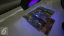 Gambar uang kertas rupiah disinari lampu ultraviolet di kantor Peruri, Karawang, Jawa Barat, Rabu (18/1). Rupiah memiliki sistem pengamanan tiga level dan menjadi mata uang yang pengamanannya sangat kompleks. (Liputan6.com/Faizal Fanani)