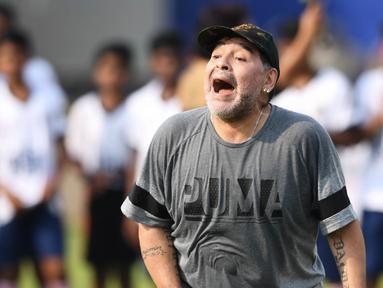 Legenda sepak bola, Diego Maradona, memberikan pelatihan kepada anak-anak di Barasat, Selasa (12/12/2017). Kunjungan ini dilakukan pria asal Argentina itu dalam rangkaian liburan. (AFP/Dibyangshu Sarkar)