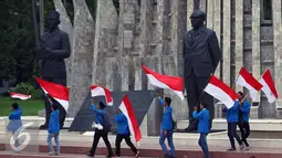 Mahasiswa mengibarkan bendera merah putih di depan Patung Soekarno - Hatta di Tugu Prooklamasi, Jakarta, Kamis (3/11). Ribuan mahasiswa ini menyatakan sikap terhadap aksi 4 November besok agar berjalan dengan damai. (Liputan6.com/Johan Tallo)