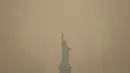 Patung Liberty yang diselimuti langit berkabut difoto dari Staten Island Ferry di New York, Rabu, 7 Juni 2023. (AP Photo/Yuki Iwamura)