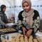 Para wanita menyiapkan biskuit tradisional "kaak" yang berbentuk cincin menjelang Idul Fitri, hari raya yang menandai berakhirnya bulan puasa suci Ramadan, di Kota Gaza pada 16 Maret 2026. (Omar AL-QATTAA/AFP)