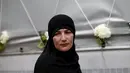 Seorang wanita tampak lesu saat berdiri di depan truk yang membawa 136 peti mati korban pembantaian Srebrenica, di desa Visoko, Bosnia-Herzegovina, Kamis, (9/7/2015). Rencananya, jenazah akan dimakamkan pada 11 Juli mendatang. (REUTERS / Stoyan Nenov)
