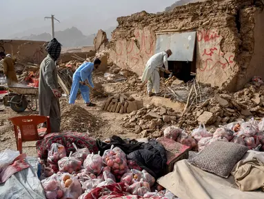 Para pemilik toko di Afghanistan mencari sisa-sisa toko mereka yang rusak di sepanjang jalan raya, menyusul gempa bumi di Tang-e Tashkurgan, distrik Khulm, provinsi Samangan, pada Senin 3 November 2025. Sedikitnya 20 orang dinyatakan tewas dan lebih dari 320 orang terluka setelah gempa bumi mengguncang wilayah utara Afghanistan. (Atif Aryan/AFP)