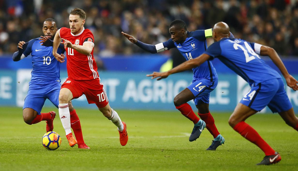 Gelandang Wales, Aaron Ramsey, berusaha melewati pemain Prancis pada laga persahabatan di Stadion Stade de France, Sabtu (11/11/2017). Prancis menang 2-0 atas Wales. (AP/Francois Mori)
