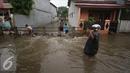 Warga melintasi banjir yang menggenangi Jalan Ketapang di kawasan Pasar Minggu, Jakarta, Selasa (4/10). Banjir yang berasal dari luapan Kali Anur tersebut menyebabkan Jalan Ketapang tidak bisa dilewati kendaraan. (Liputan6.com/Immanuel Antonius)