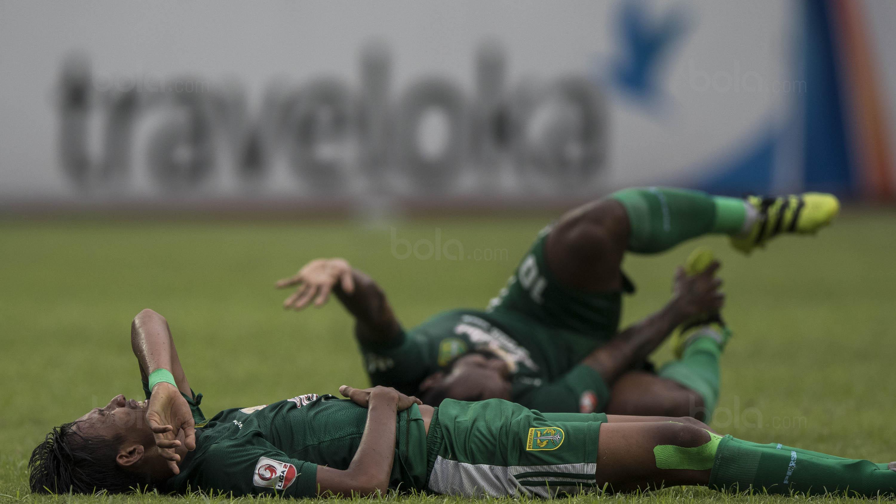 Pemain Persebaya, Rishadi Fauzi dan Nerius Alom, kesakitan saat melawan Martapura FC pada laga semifinal Liga 2 2017 di Stadion GBLA, Bandung, Sabtu (25/11/2017). Persebaya menang 3-1 atas Martapura FC. (Bola.com/Vitalis Yogi Trisna)