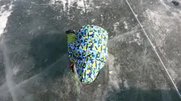 Peserta memancing ikan trout melalui lubang yang mereka buat di atas sungai beku di Hwacheon, Korea Selatan, Sabtu (5/1). Kontes ini merupakan bagian dari festival es tahunan yang menarik lebih dari satu juta pengunjung setiap tahun. (AP/Ahn Young-joon)