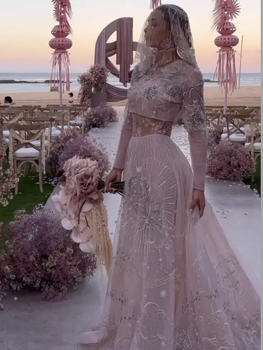 Adinia Wirasti tampil mengenakan gaun bernuasa pink dengan atasan lengan panjang crop top serta rok panjangnya. Lengkap mengenakan veil. @adiniawrst