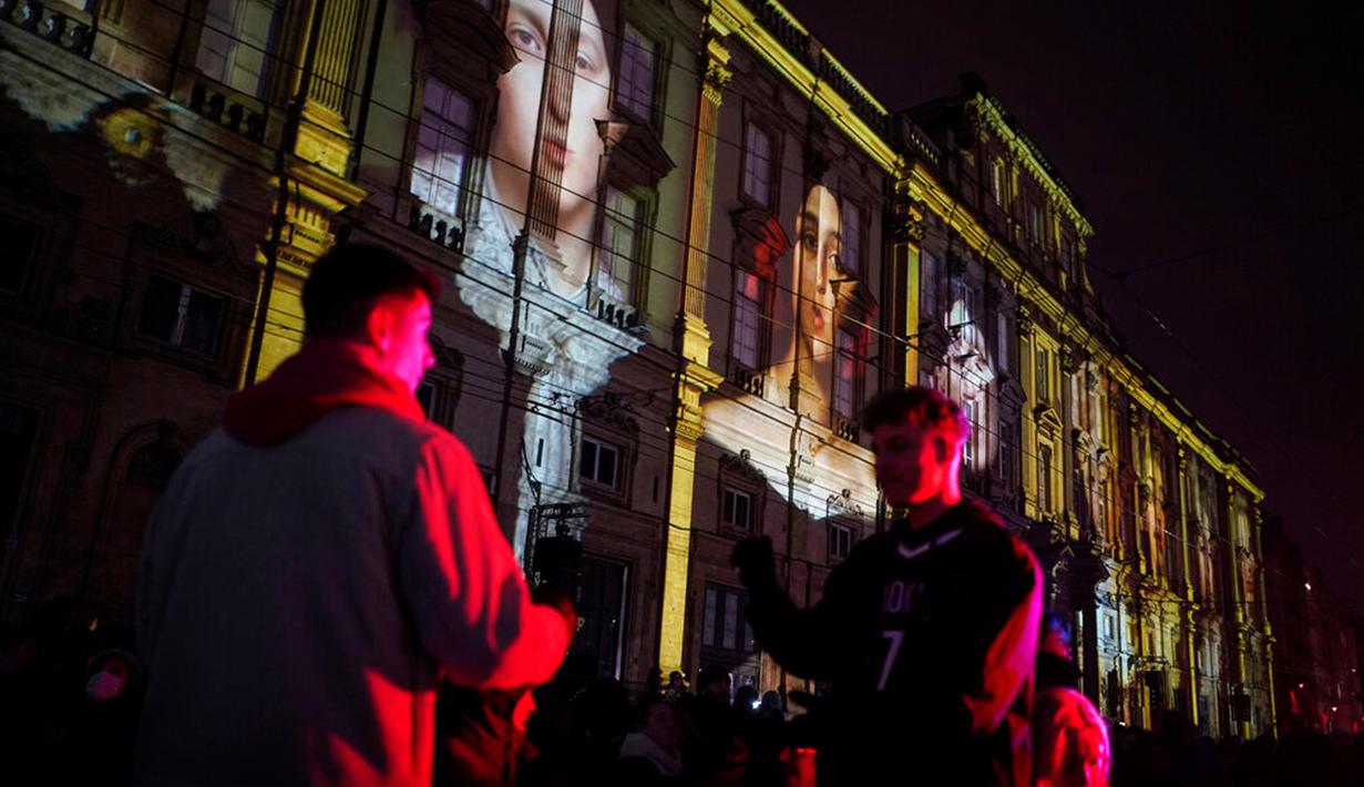 Orang-orang menghadiri pertunjukan cahaya malam di Lyon, Prancis, 8 Desember 2022. Jutaan orang diperkirakan akan menyaksikan acara Festival Cahaya selama empat hari di kota tersebut. (AP Photo/Laurent Cipriani)