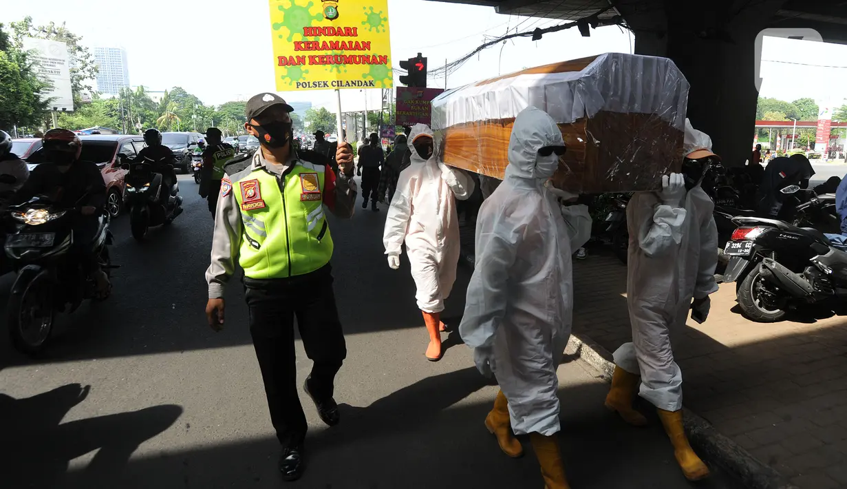 Petugas Gabungan membawa peti mati di hadapan pengendara bermotor di perempatan Fatmawati, Jakarta Selatan, Kamis (3/9/2020). Kegiatan tersebut dalam rangka sosialisasi kewaspadaan dan kesadaran warga ibukota di tengah pandemi corona yang dapat menyebabkan kematian. (merdeka.com/Arie Basuki)