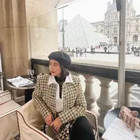 Berlatarkan louvre pyramid, Prilly tampil kece dengan setelan tweed blazer kuning dan topi baret. [@prillylatuconsina96].