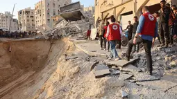 Warga Gaza bersama tim dari Komite Palang Merah Internasional (ICRC) melakukan pencarian korban yang masih tertimbun di reruntuhan bangunan akibat serangan Isarel pada 17 Oktober 2025. (Omar AL-QATTAA/AFP)