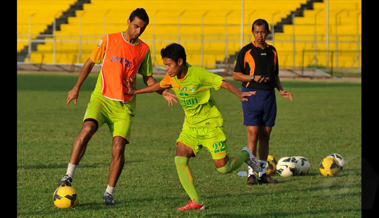 Pemain asing Persebaya asal Brasil, Otavio Dutra (kiri) mengecoh rekan setimnya saat latihan di Stadion H Agus Salim, Padang, Jumat (16/1/2015). Persebaya akan berhadapan dengan Semen Padang di laga perdana SCM Cup 2015 grup A. (Liputan6.com/Johan Tallo)