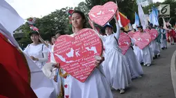 Sejumlah umat Kristiani membawa lambang hati saat kirab perayaan Paskah di sekitar Jalan Medan Merdeka Selatan, Jakarta, Minggu (4/1). Kirab dimulai dari Bundaran Hotel Indonesia dan berakhir di gereja Immanuel Jakarta. (Liputan6.com/Helmi Fithriansyah)