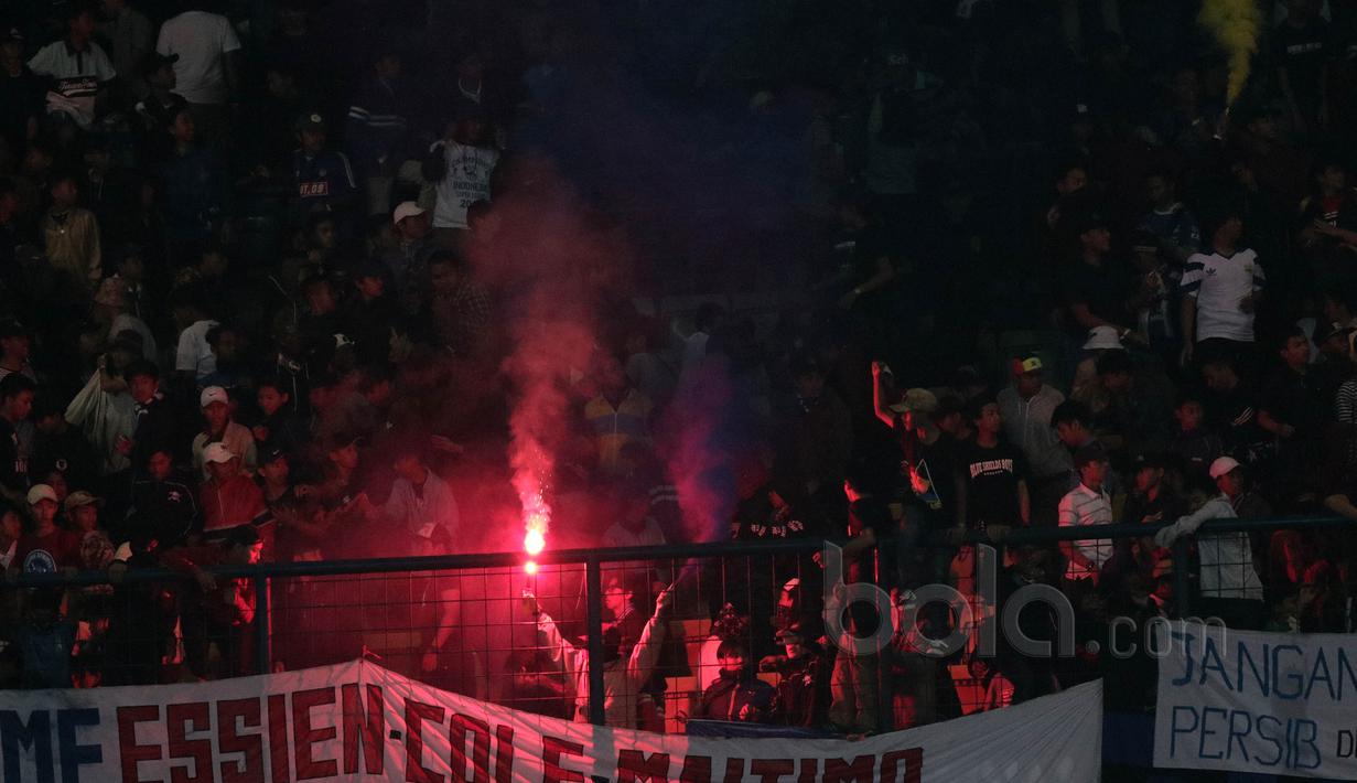 Sekelompok suporter menyalakan flare usai laga Persib Bandung melawan Persipura Jayapura pada laga Liga 1 2017 di Stadion GBLA, Minggu (7/5/2017). Persib Bandung menang 1-0. (Bola.com/Nicklas Hanoatubun)