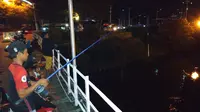 Di Jembatan Lama yang di bawahnya mengalir Sungai Brantas, belasan orang tiap malam Ramadan memancing, melatih kesabaran. (Liputan6.com/ Dian Kurniawan)