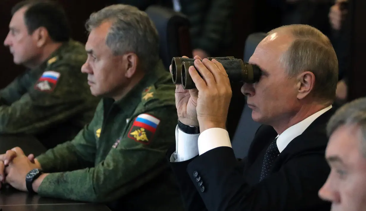 Vladimir Putin meneropong latihan militer Rusia Zapad-2017 dengan Belarus di Luzhsky di wilayah Leningrad (18/9). Latihan ini diikuti 13.000 personel Rusia dan Belarusia dengan peralatan dan alat tempur lengkap. (AFP Photo/Sputnik/Mikhail Klimentyev)